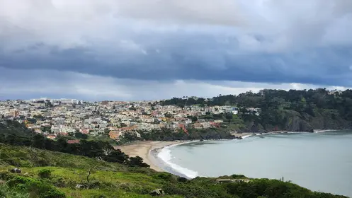 bir plaj manzarası arka planda bir şehir ile